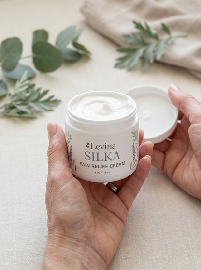 Hands holding an open jar of Levina Silka showing the silky cream